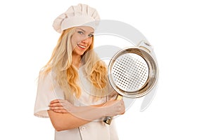 Young blonde chef woamn holds kitchenware as she prepares to coo