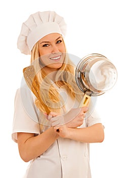 Young blonde chef woamn holds kitchenware as she prepares to coo