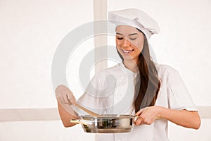 Young blonde chef woamn holds kitchenware as she prepares to coo