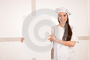 Young blonde chef woamn holds kitchenware as she prepares to coo