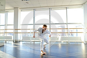 Young blonde dancer enjoys winning in white suit and makes warm