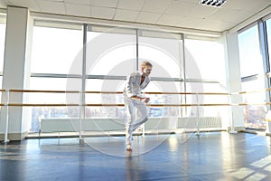 Young blonde dancer enjoys winning in white suit and makes warm