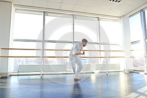 Young blonde dancer enjoys winning in white suit and makes warm