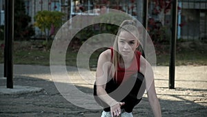 young blonde female in activewear sitting on ground gesturing with her hands