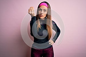 Young blonde fitness woman wearing sport workout clothes over isolated background Doing Italian gesture with hand and fingers