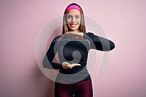 Young blonde fitness woman wearing sport workout clothes over isolated background gesturing with hands showing big and large size