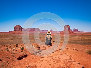 Young blonde girl admires panorama from Artist`s Point in Oljato Monument Valley