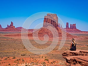 Young blonde girl admires panorama from Artist`s Point in Oljato Monument Valley