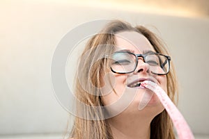 Young blonde girl biting a lollipop