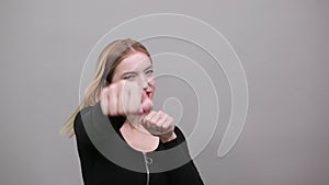 Young blonde girl in black jacket woman Boxing, punches