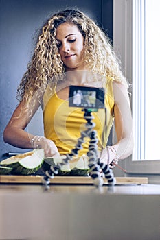 Young blonde girl cutting a melon