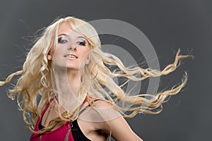 Young blonde girl with flying long hair