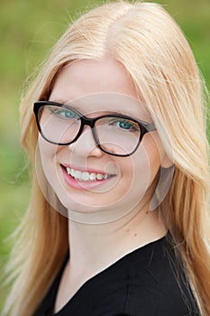 Young blonde girl with glasses smiling