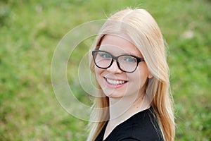 Young blonde girl with glasses smiling