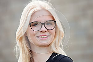 Young blonde girl with glasses smiling