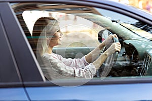 Young blonde girl safely driving her car