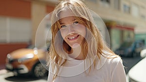 Young blonde girl smiling confident using touchpad at street