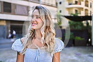 Young blonde girl smiling happy standing at the cityl