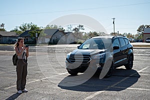 A young blonde girl traveling along route 66 with her black van taking pictures