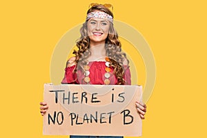 Young blonde girl wearing hippie style holding there is no planet b banner looking positive and happy standing and smiling with a