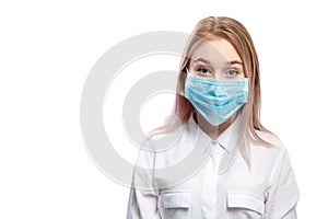 Young blonde girl in a white blouse and a medical mask on a white background