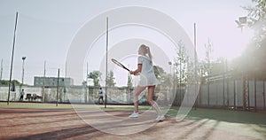 Young blonde hair sportiv woman playing tennis professional outside on sunny day at tennis court.