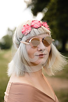 Young blonde hippie woman with heart glasses and flower band