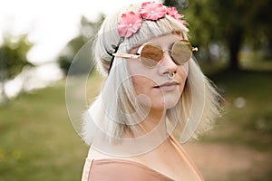 Young blonde hippie woman with heart glasses and flower band