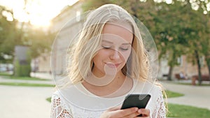 Young Blonde Lady Using a Phone in Town