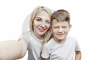 Young blonde mom with her son 7 years old make a selfie. Love and tenderness. Isolated on white background