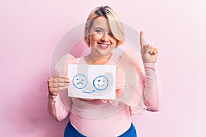 Young blonde plus size woman asking for positive change holding paper with emotion message smiling with an idea or question