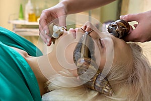 Young blonde receiving facial snails massage.