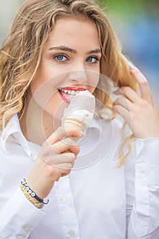 Young blonde teen girl eating sweet ice cream