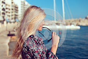 Young blonde traveler woman at sea profile view