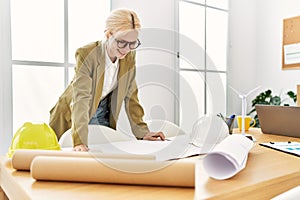 Young blonde woman architect looking house plans smiling at office