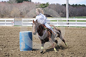 Young blonde woman barrel racing photo