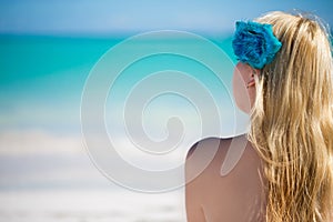 Young blonde woman in bikini near sea