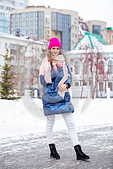 Young blonde woman in blue down jacket in winter street