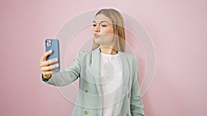 Young blonde woman business worker smiling confident make selfie by smartphone over isolated pink background