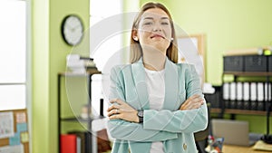 Young blonde woman business worker smiling confident standing with arms crossed gesture at office