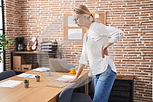 Young blonde woman business worker suffering backache at office