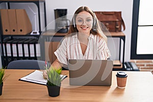 Young blonde woman call center agent smiling confident working at office