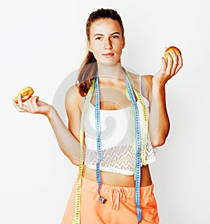 young blonde woman choosing between donut and apple fruit isolat