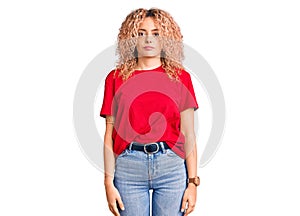 Young blonde woman with curly hair wearing casual red tshirt looking sleepy and tired, exhausted for fatigue and hangover, lazy