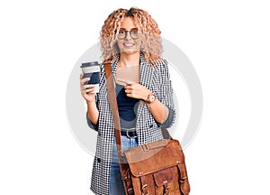 Young blonde woman with curly hair wearing leather bag and drinking a take away cup of coffee smiling happy pointing with hand and