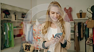 Young blonde woman customer making selfie by the smartphone at clothing store