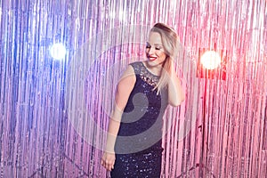 Young blonde woman dancing at night disco club. Party, holidays and celebration concept.