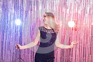 Young blonde woman dancing at night disco club. Party, holidays and celebration concept.
