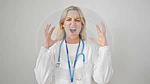 Young blonde woman doctor angry and stressed over isolated white background