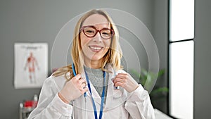 Young blonde woman doctor smiling confident wearing stethoscope at clinic